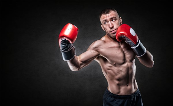 Professional boxer in red gloves practicing punches. Boxing concept.