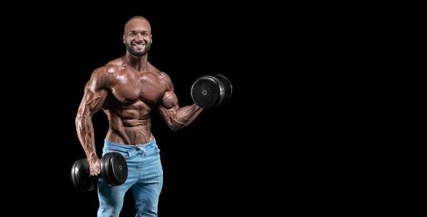Isolated muscular man on a black background. Bodybuilding and fitness concept. Panorama.