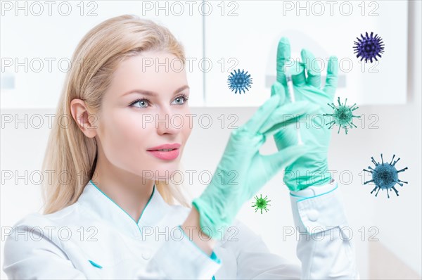 Portrait of a blonde girl in a medical gown with a syringe in her hands. Covid vaccine concept. Epidemic