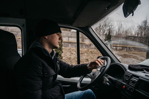 Young truck driver sitting behind the wheel