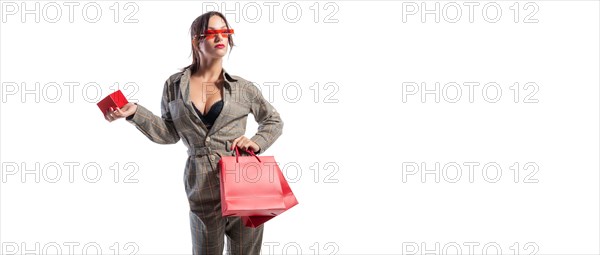 Charming brunette in glasses posing in the studio with red bags and a box for jewelry. White background. Shopping concept.