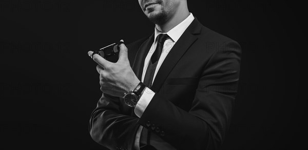 Image of an adult stylish man in a suit with a cigar. Cigar clubs concept.