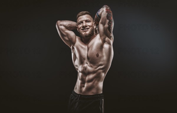 Young muscular guy posing in the studio. Fitness and nutrition concept.