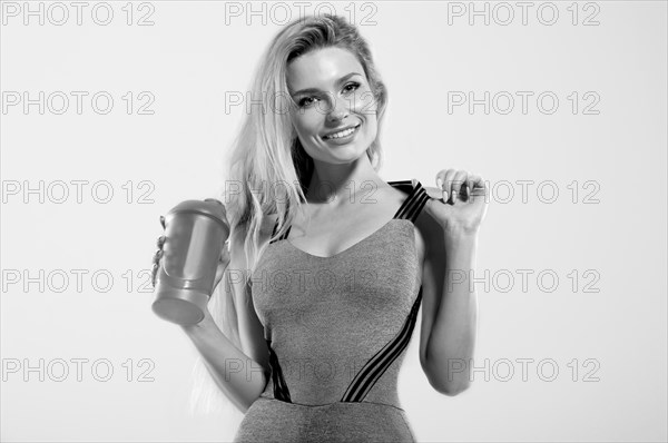 Charming model posing in studio with shaker in hands.