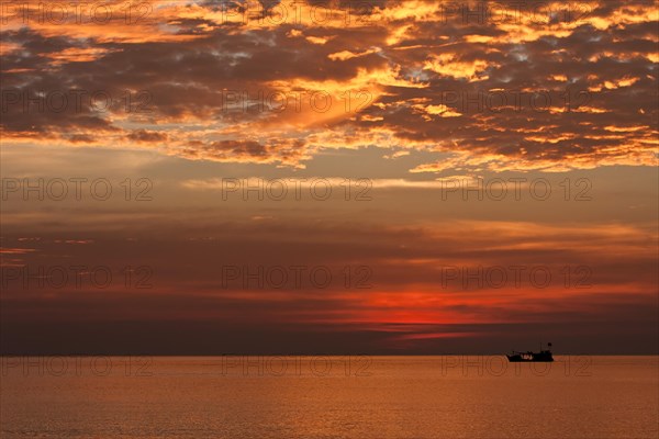 Red sunset and fishing boat