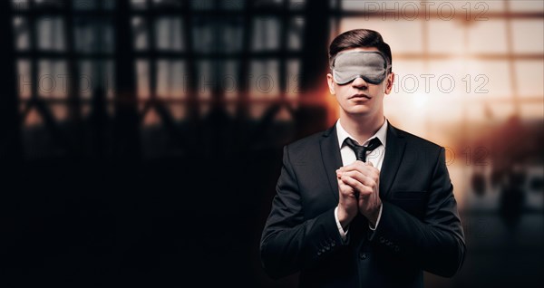 Man in a business suit and a mask for sleeping is standing at the airport. He is praying. Airline concept. Caring for passengers.