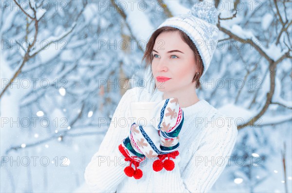 Portrait of a beautiful woman holding a cup of tea in her hands. Concept of Christmas