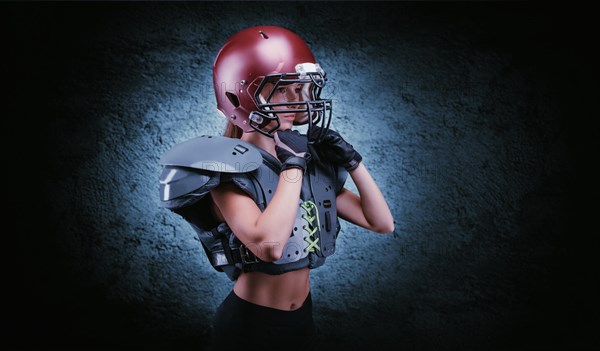 Brutal portrait of a girl in the uniform of an American football team player. Equipment advertising. Sports concept. Shoulder pads.