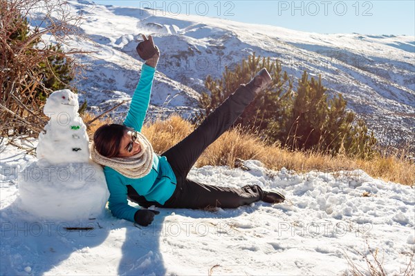 Winter Playtime Latina Woman Having Fun Next to Snowman in Snowy Scene