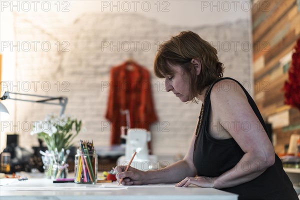 A fashion designer drawing a Vertical shot. Copy space