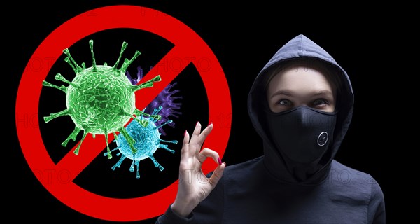 Portrait of a girl in a protective mask who shows up her finger against the background of the stop viruses sign.