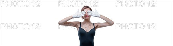 Beautiful young woman in white gloves covered her eyes with her hands