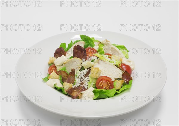 Gourmet Caesar Salad with Bacon. Top view. White background. Healthy eating concept.