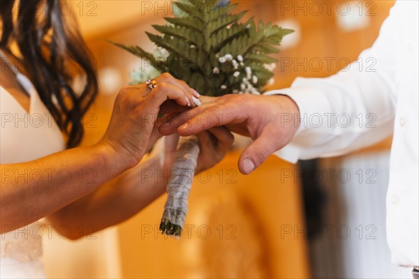 Woman putting the ring on the groom at a wedding