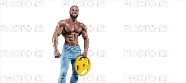 Sportsman posing on a white background in jeans with a dumbbell in his hand. Fitness