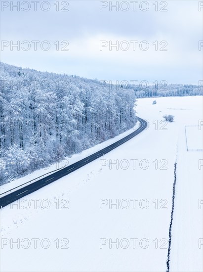 A road runs through a snow-covered landscape