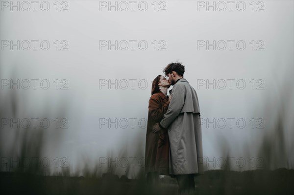 Couple in love in a foggy field. Relationship crisis and dramatic love concept