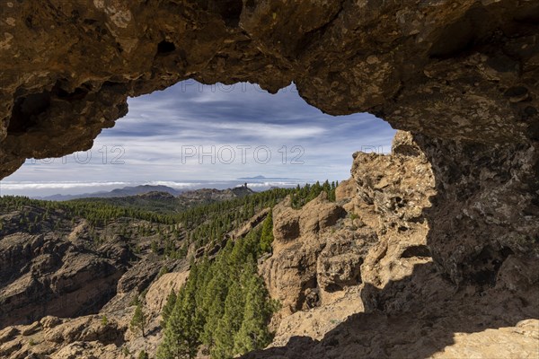 View through a rock arch to Roque Nublo and the Teide mountain peak on the neighbouring island of Tenerife