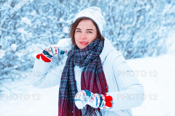 Portrait of a beautiful girl throwing a snowball. Concept for Christmas holidays