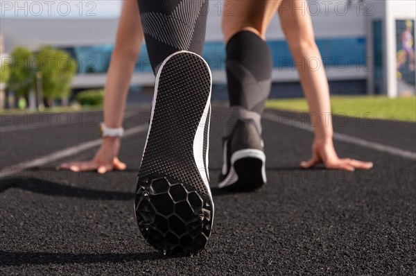 Professional runner stands on the track and prepares for the start of the race. Sports concept.