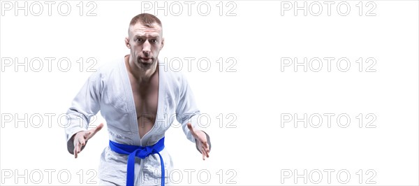 Sportsman in a kimono with a blue belt. White background. The concept of karate and judo competitions.