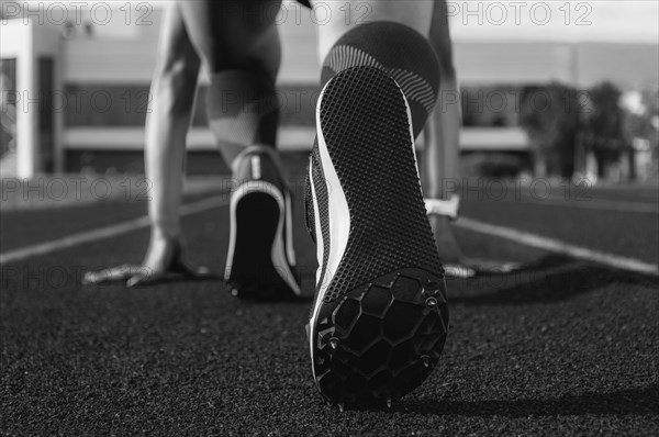 Image of spiked shoes at the start line of the track. Running concept.