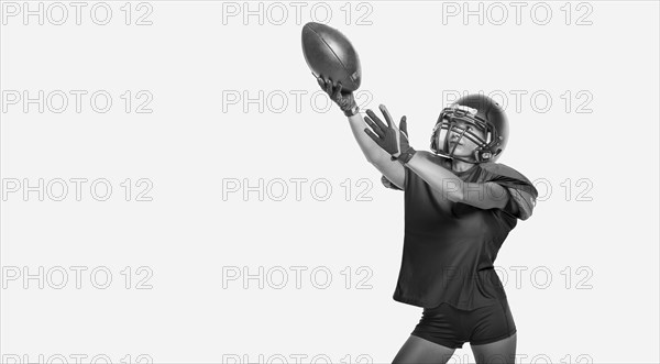 Black and white images of a sports girl in the uniform of an American football team player. Sports concept. White background.