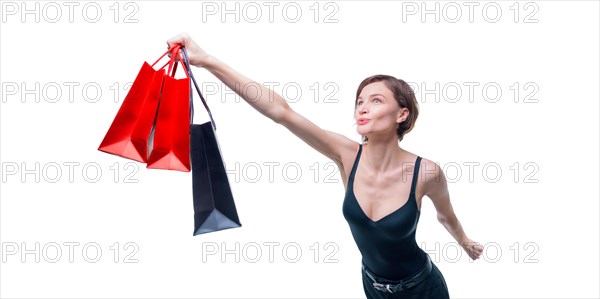 Portrait of a beautiful woman with packages. She enthusiastically rushes shopping. Shopaholic concept. Shopping centers. Sales