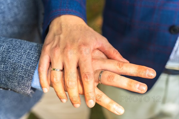 Detail of very happy gay bride and groom showing the ring at the ceremony