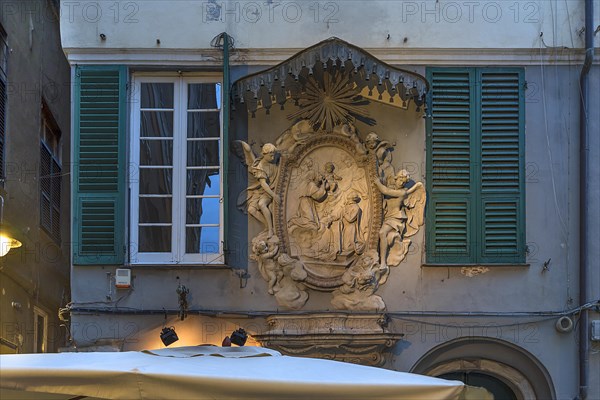 Large relief of a saint with canopy on a residential building