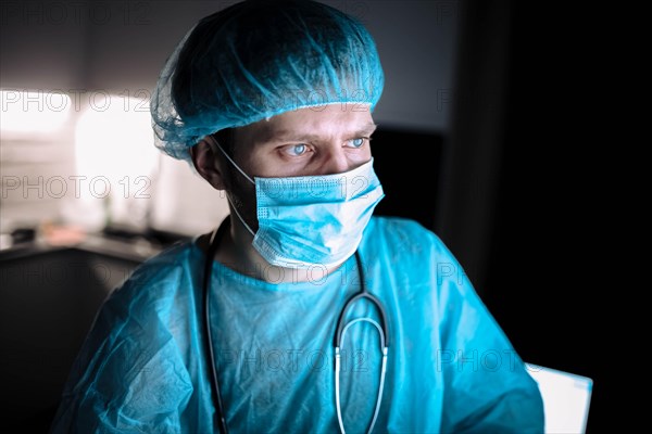 Male scientist doctor working in a laboratory with a monitor in a sterile uniform