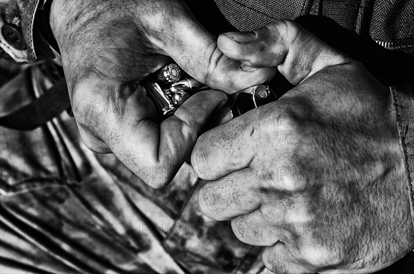 The fighter prepares a clip with bullets before the next fight.