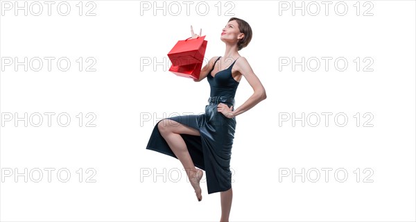 Stylish adult tall woman posing in studio with gift bags. Shopping concept. Shopping centers.