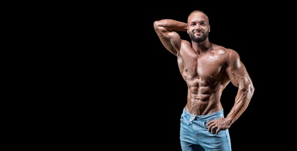 Isolated muscular man on a black background. Bodybuilding and fitness concept. Panorama.