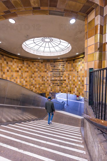 Person descending in an underground station with an interesting staircase