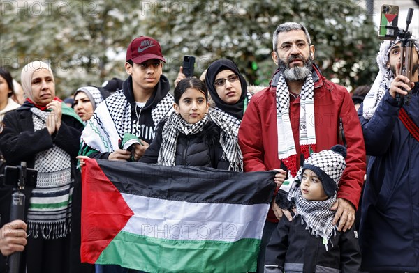 A family shows a Palestinian flag during the demonstration Freedom for the people of Gaza