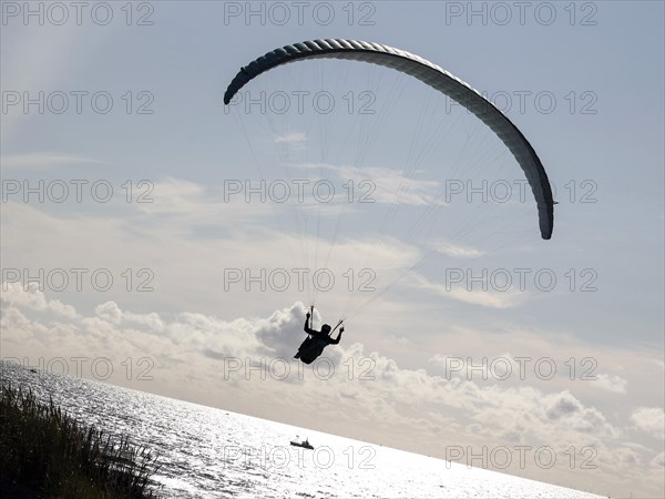 Paragliders flying over a beach at the North Sea