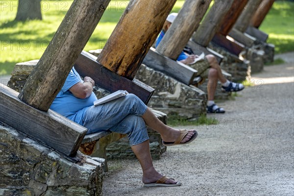 Men relaxing on benches between supporting beams of Gradierbau I