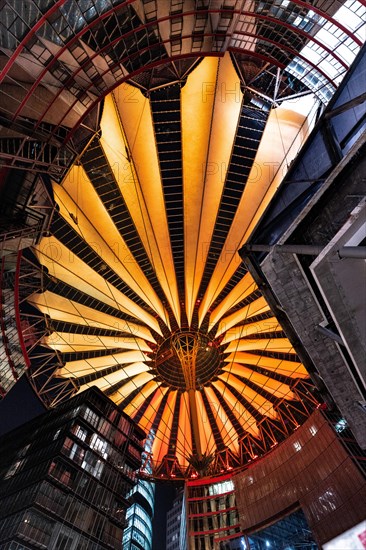 Modern roof construction with warm orange lighting in the city