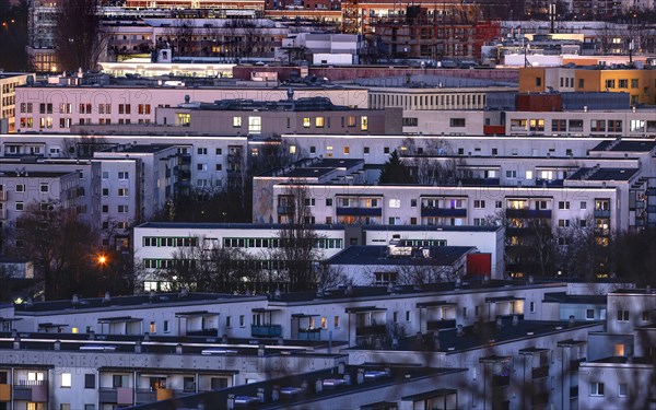 View in the evening at blue hour of high-rise buildings and apartment blocks with rental flats and condominiums in the Berlin district of Marzahn-Hellersdorf