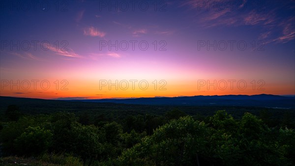 Sun sets behind the Catskills Mountains