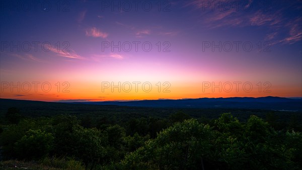 Sun sets behind the Catskills Mountains