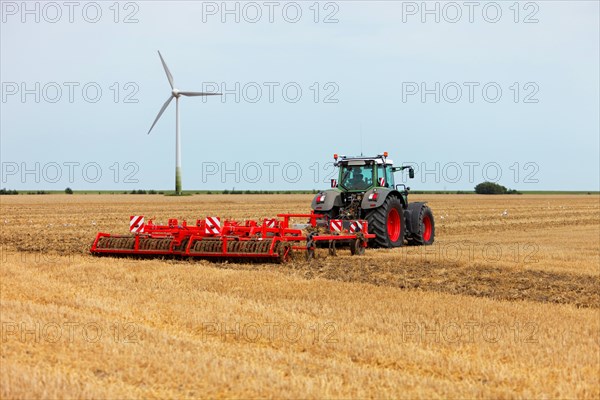 Tractor pulls a harrow behind it