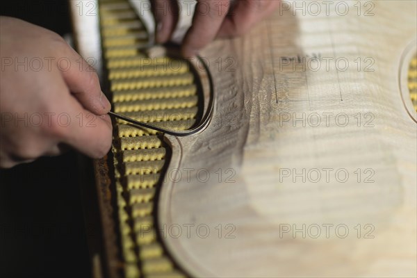 Unrecognizable luthier lute maker artisan hands in his workshop try