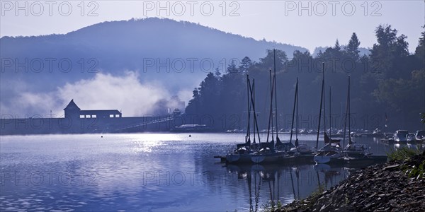 Eder dam with dam wall and pleasure boats on the Edersee in the early morning