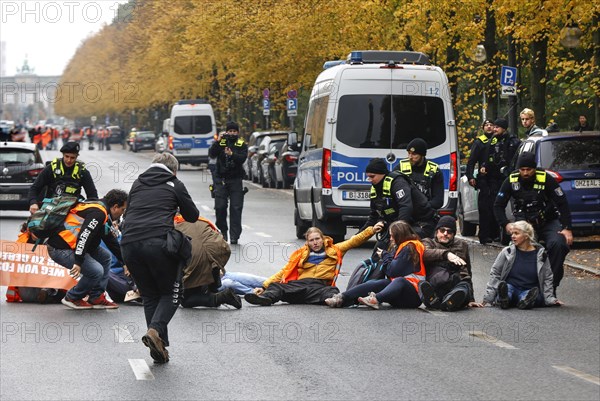 Police officers carry last generation climate activists from Strasse des 17. The Last Generation has called for a mass occupation action