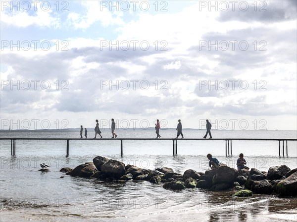 People walking on the infinite bridge . The bridge is a work of art built for Sculpture by the Sea