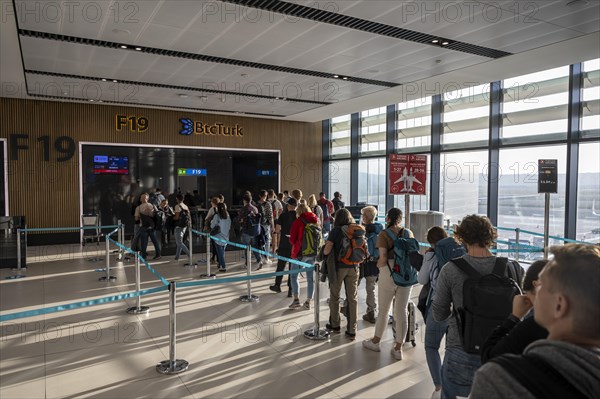 People queuing at the gate to board the aircraft