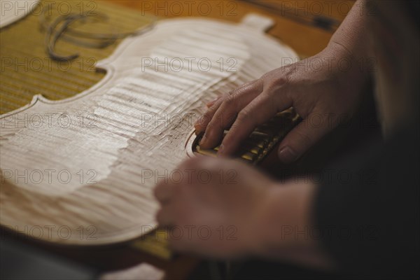 Unrecognizable luthier lute maker artisan hands in his workshop try