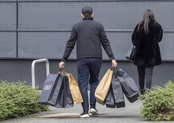 Consumer tourist lugging shopping bags